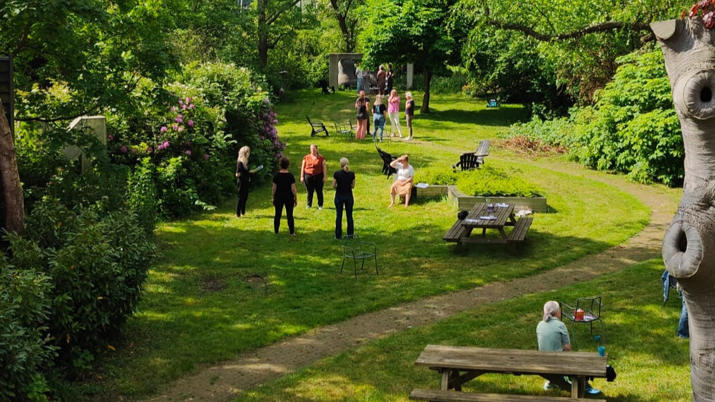 Groepjes cursisten werken in de tuin