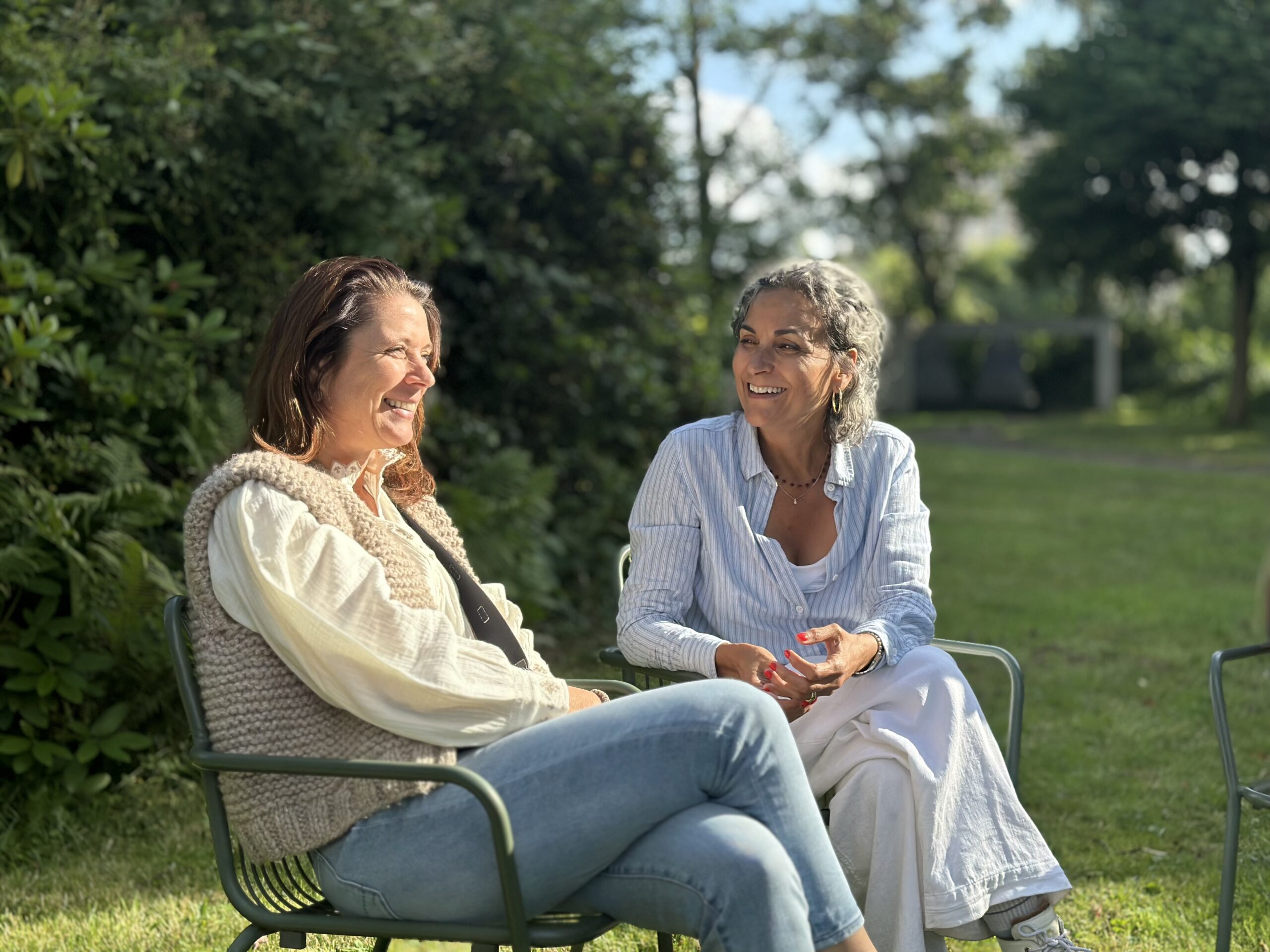 Christine en Renée in de tuin, lachend